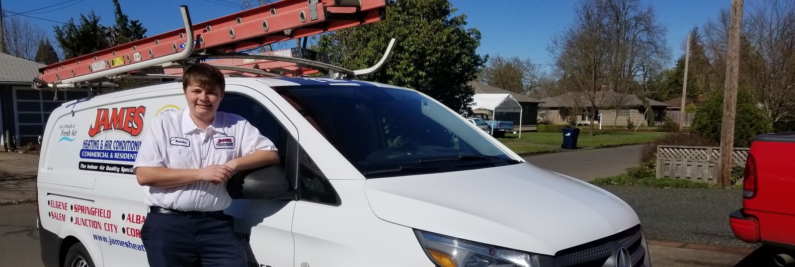 James Heating & Air Conditioning technician standing beside company service van before a Salem AC repair appointment