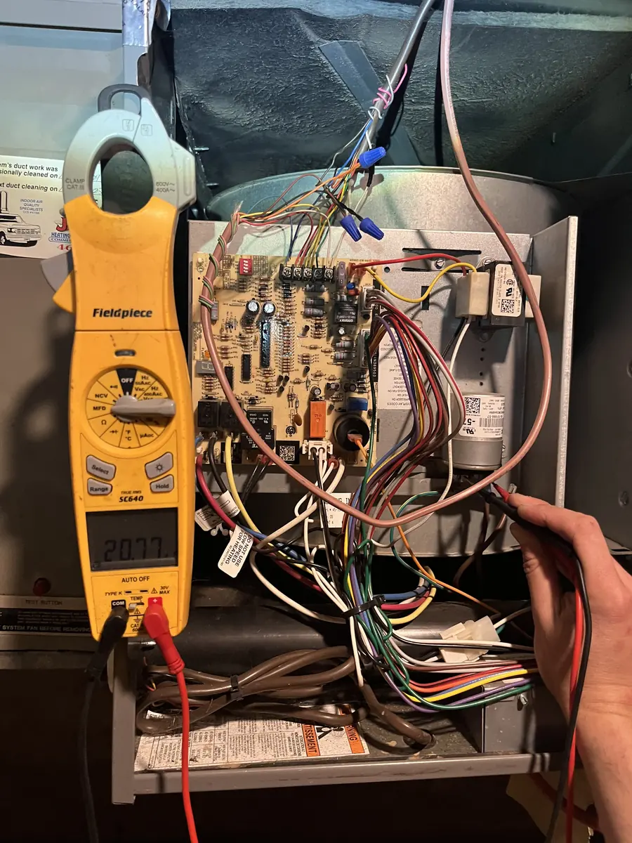 Multimeter testing a furnace control board Multimeter testing a furnace control board