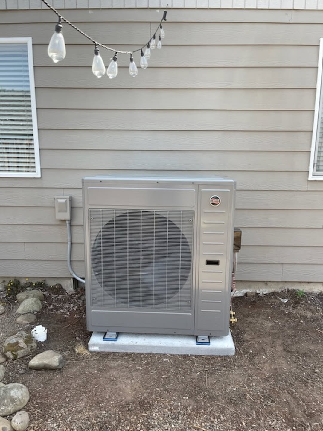 New heat pump condenser unit installed outside a residential home