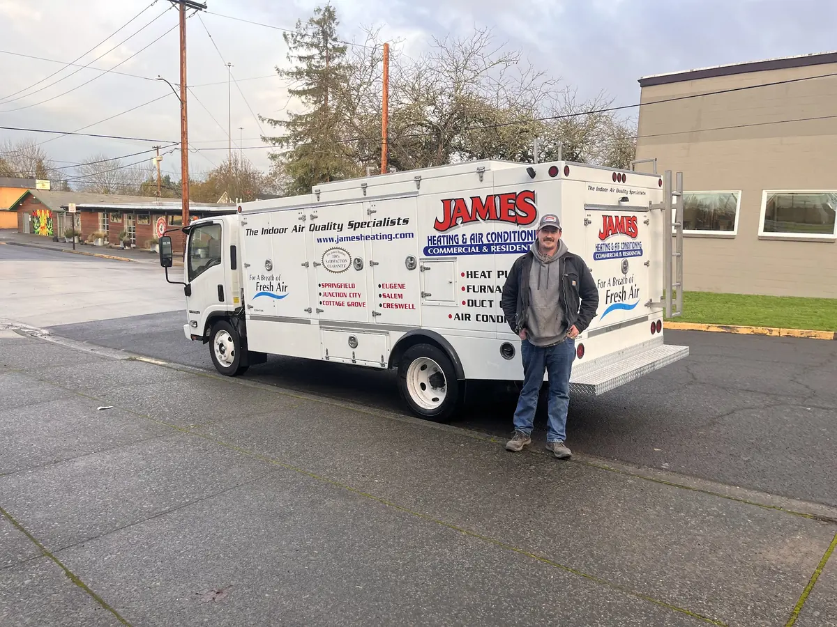 James Heating technician beside a box service truck James Heating technician beside a box service truck